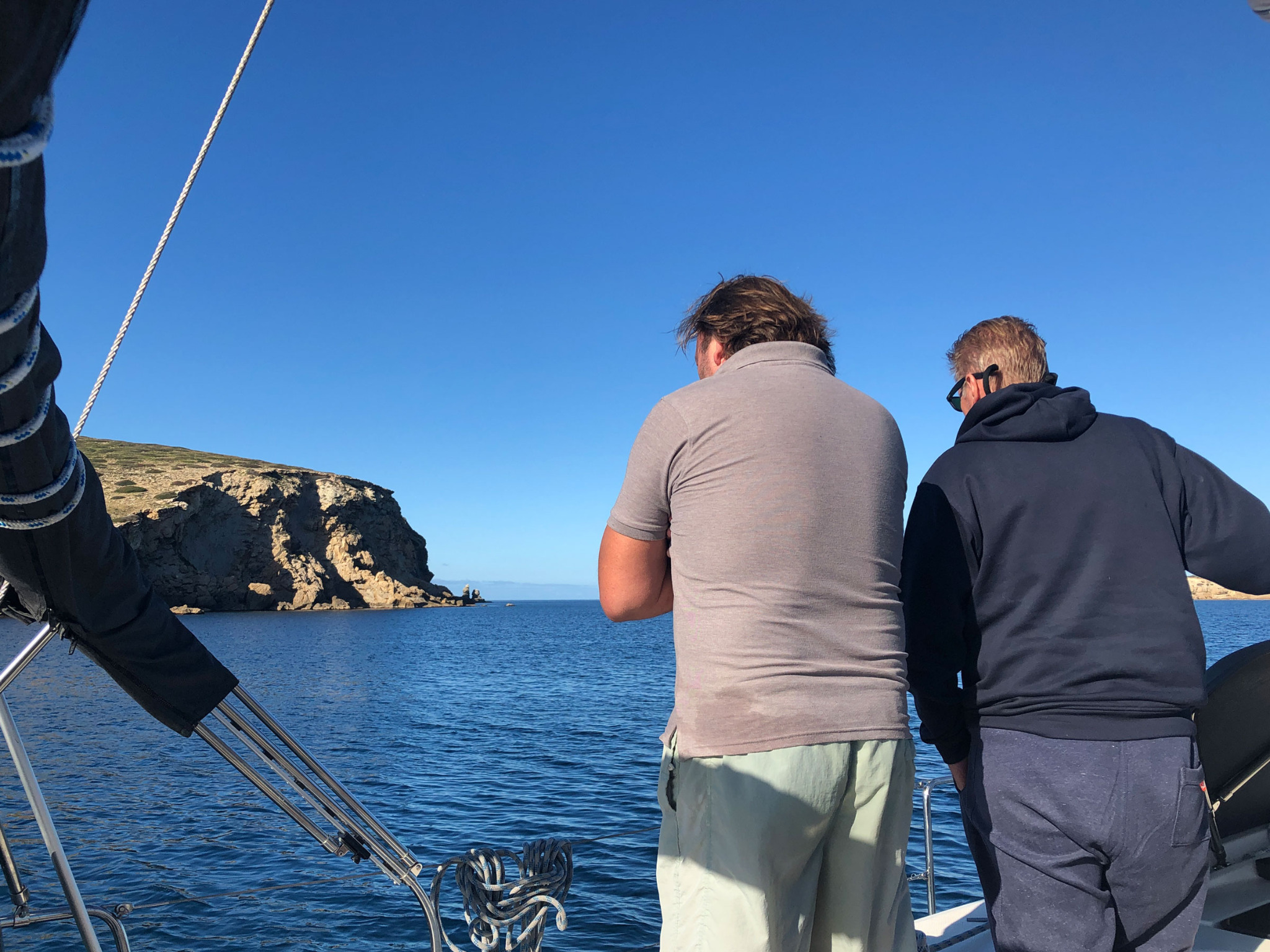 Crew an Bord einer Segelyacht vor einer Küste