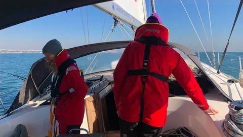 Crew im Cockpit der SY HERA bei Manövervorbereitung und Leinenarbeit im Skippertraining